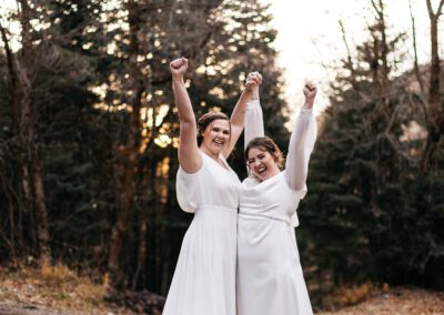 Brides cheering with arms in the air.