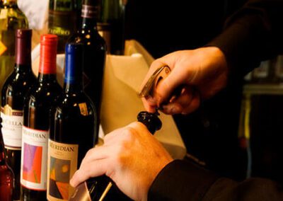 Bartender opening a bottle of wine with wine opener
