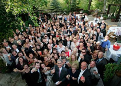 Wedding party giving cheers outdoors on Millcreek Inn patio.